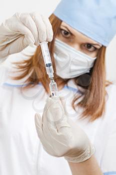 nurse prepares a vaccine for injection