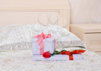beautiful gift box and red rose on the bed