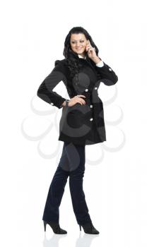 Glamorous woman in black coat speaks on a mobile phone. isolated on white
