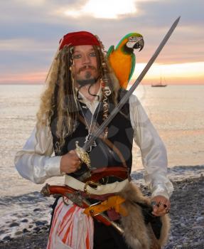 The pirate with a parrot on the seashore