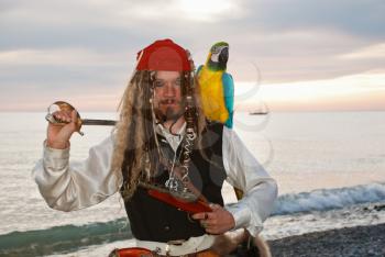 The pirate with a parrot on the seashore