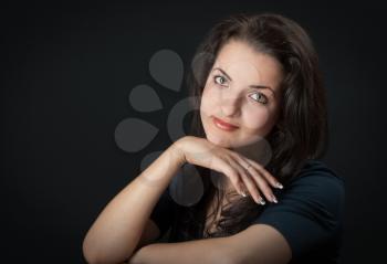 portrait of a beautiful young brunette on a black background