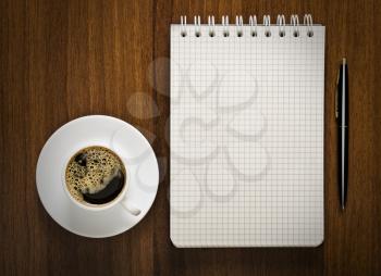 notebook with pen and cup of coffee on your desktop