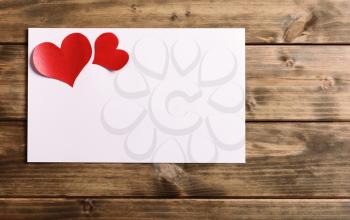 greeting card with a red heart and space for text on a wooden background