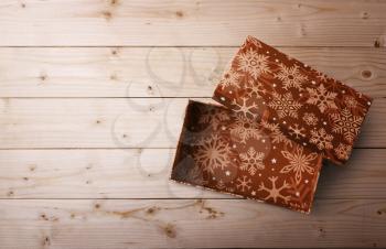 open Christmas gift box on a wooden background