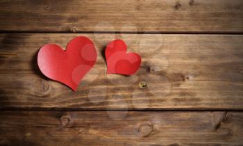 two red hearts on a wooden background. valentine's day