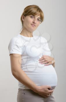 Pregnant woman holding her hands on her stomach