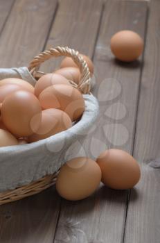 closeup lot of chicken eggs in a basket on a wooden table