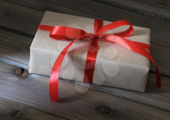 Vintage gift box wrapped in kraft paper on wooden background