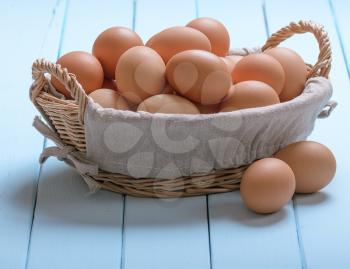 Eggs in a basket on blue wooden table