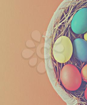 colorful easter eggs in a basket with hay. toning in retro style