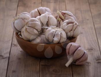 bunch of garlic in a wooden bowl on the table