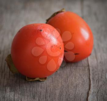 Delicious orange persimmons on wooden table