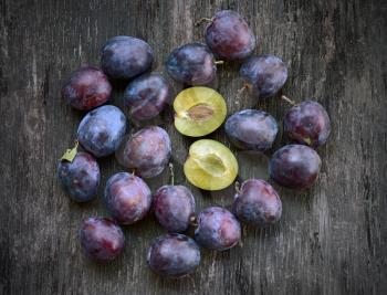 Fresh ripe plum on a wooden background