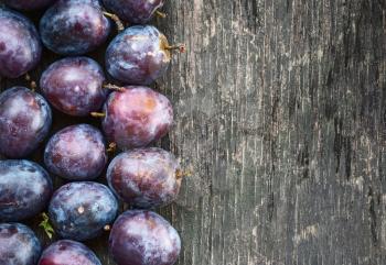 Fresh ripe plum on a wooden background