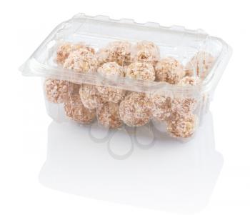 rounds candy with coconut shavings in a plastic container isolated on white with clipping paths 