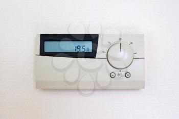 Digital Thermostat set to 19,5 degrees Celsius, isolated on white wall