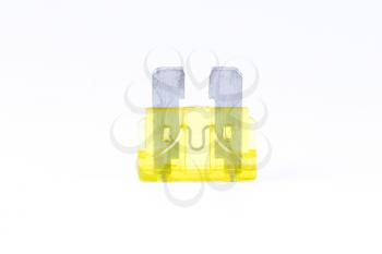 A yellow car fuse with a white background