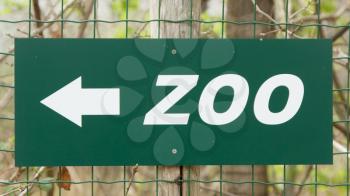 A green zoo' sign on a green fence