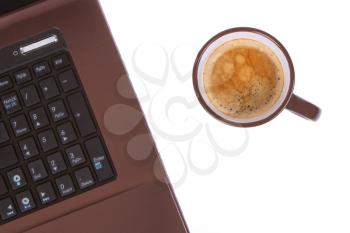 Cup of coffee near laptop, business concept