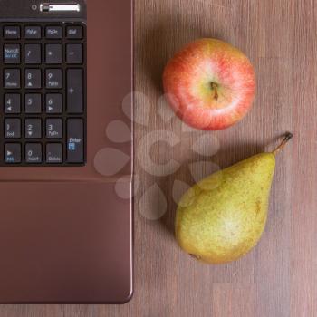 Fruit with a laptop on a wood floor