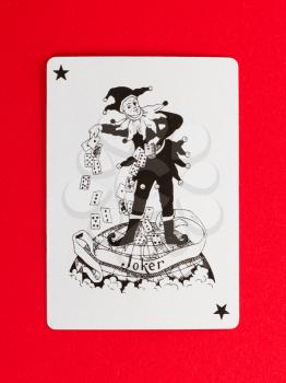 Old playing card (joker) isolated on a red background