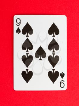 Old playing card (nine) isolated on a red background