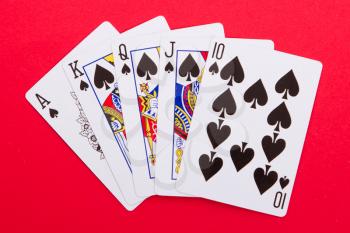 Old playing cards (royal flush) isolated on a red background
