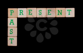 Green letters on old wooden blocks (present, past)
