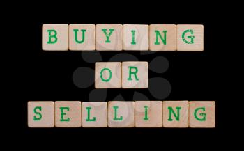 Green letters on old wooden blocks (buying or selling)