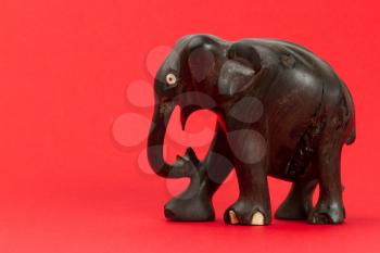 Very old ivory statue of an elephant isolated on a red beckground
