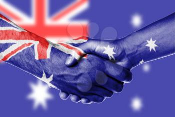 Man and woman shaking hands, wrapped in flag pattern, Australia