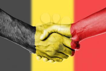 Man and woman shaking hands, wrapped in flag pattern, Belgium