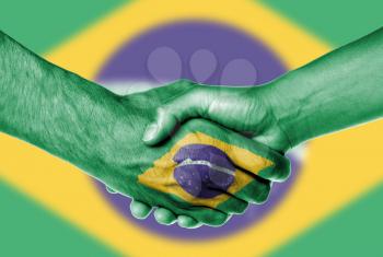Man and woman shaking hands, wrapped in flag pattern, Brazil