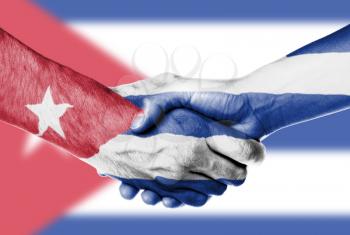 Man and woman shaking hands, wrapped in flag pattern, Cuba