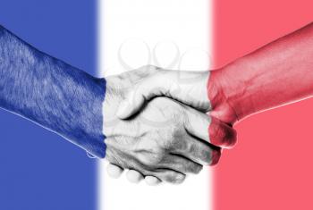 Man and woman shaking hands, wrapped in flag pattern, France