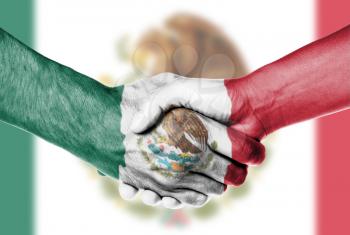 Man and woman shaking hands, wrapped in flag pattern, Mexico