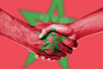 Man and woman shaking hands, wrapped in flag pattern, Morocco