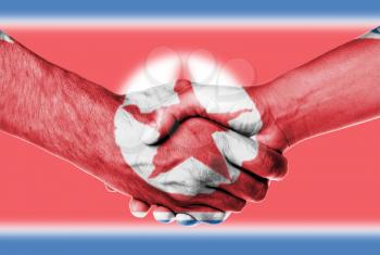 Man and woman shaking hands, wrapped in flag pattern, North Korea