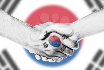 Man and woman shaking hands, wrapped in flag pattern, South Korea