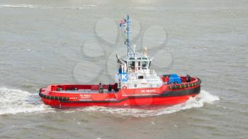 ROTTERDAM, THE NETHERLANDS - JUNE 22: Red tug is working in the harbor of Rotterdam (Holland), Rotterdam, June 22, 2012