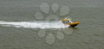 Yellow Crewtender at high speed in the harbor of Rotterdam (Holland)