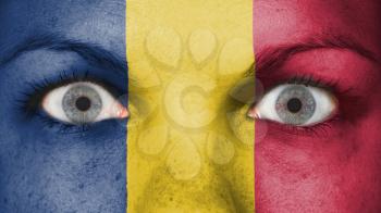 Close up of eyes. Painted face with flag of Chad