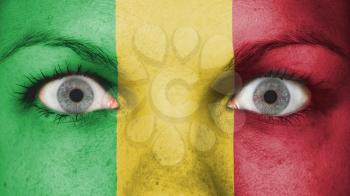 Close up of eyes. Painted face with flag of Mali