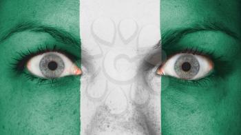 Close up of eyes. Painted face with flag of Nigeria