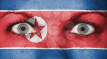 Close up of eyes. Painted face with flag of North Korea