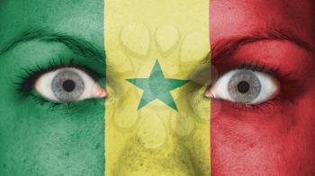 Close up of eyes. Painted face with flag of Senegal