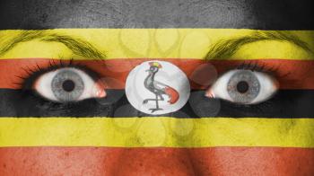 Close up of eyes. Painted face with flag of Uganda