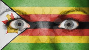 Close up of eyes. Painted face with flag of Zimbabwe