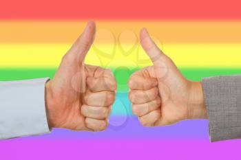 Caucasian business man and woman holding thumb up, rainbow flag